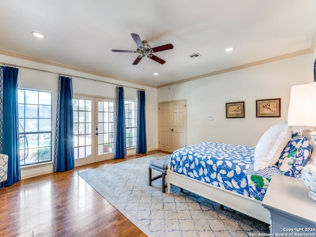 bedroom with ceiling fan, french doors, crown molding, wood-type flooring, and a closet