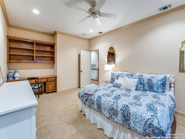 bedroom with ceiling fan, light colored carpet, built in desk, and ornamental molding