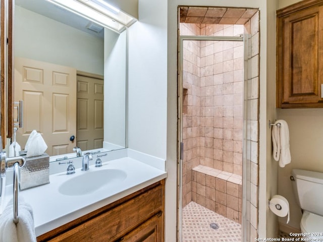 bathroom featuring vanity, toilet, and a shower with door