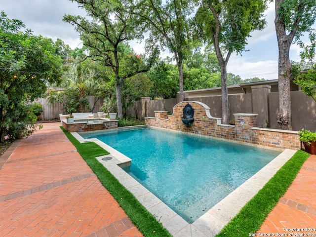 view of pool featuring a patio area and an in ground hot tub