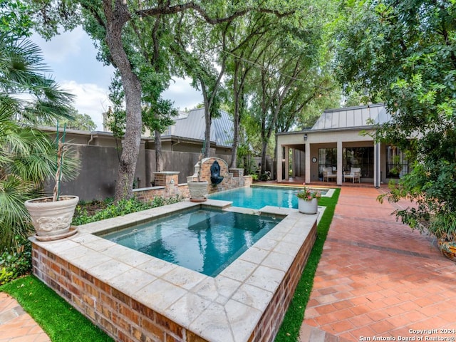 view of pool with a patio area and an in ground hot tub