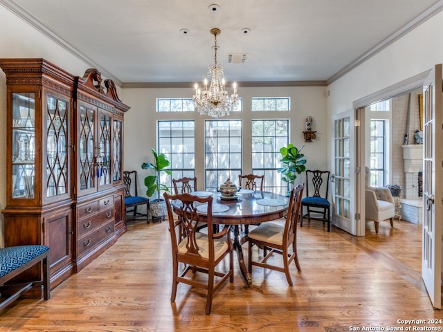 dining area with a healthy amount of sunlight, light hardwood / wood-style flooring, and an inviting chandelier