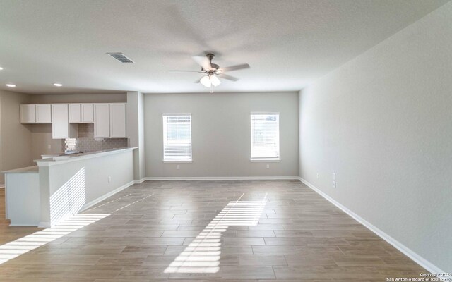 kitchen featuring white cabinetry, stove, light tile flooring, and ceiling fan