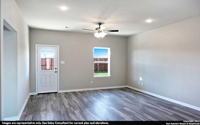 spare room featuring dark wood-type flooring and ceiling fan