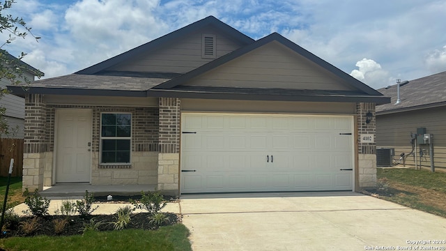 view of front of property with a garage and central AC