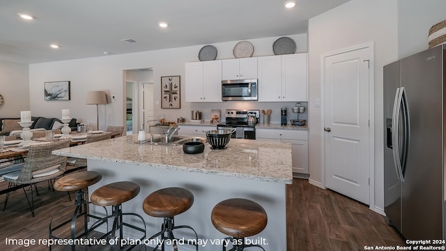 kitchen featuring sink, white cabinetry, dark hardwood / wood-style floors, a kitchen island with sink, and appliances with stainless steel finishes