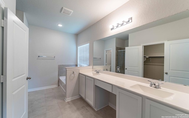 bathroom featuring vanity, tile patterned flooring, and shower with separate bathtub