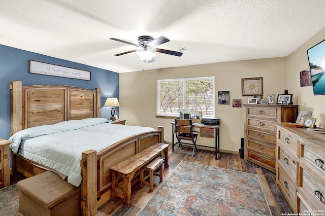 bedroom featuring dark wood-type flooring, ceiling fan, and a textured ceiling