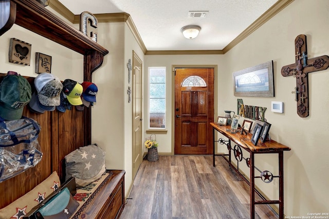 entryway featuring hardwood / wood-style flooring, a textured ceiling, and crown molding