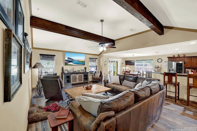 living room with beamed ceiling, ceiling fan, and light wood-type flooring