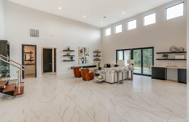 living area with marble finish floor, recessed lighting, visible vents, and bar