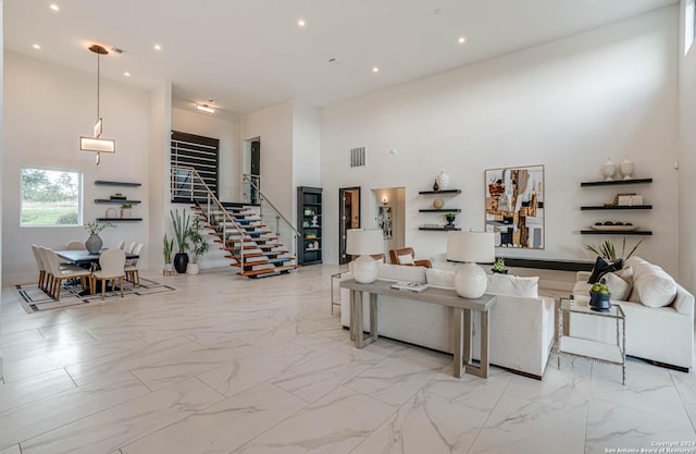 living room featuring visible vents, a towering ceiling, marble finish floor, stairs, and recessed lighting
