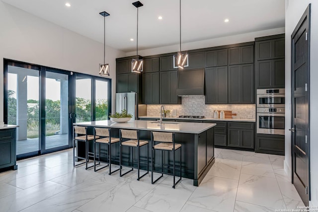 kitchen with marble finish floor, custom range hood, backsplash, appliances with stainless steel finishes, and a sink