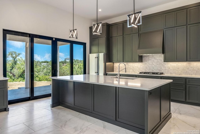 kitchen featuring custom exhaust hood, pendant lighting, light tile floors, sink, and a kitchen island with sink