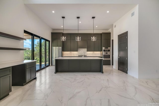 kitchen with backsplash, hanging light fixtures, light tile floors, and a kitchen island with sink