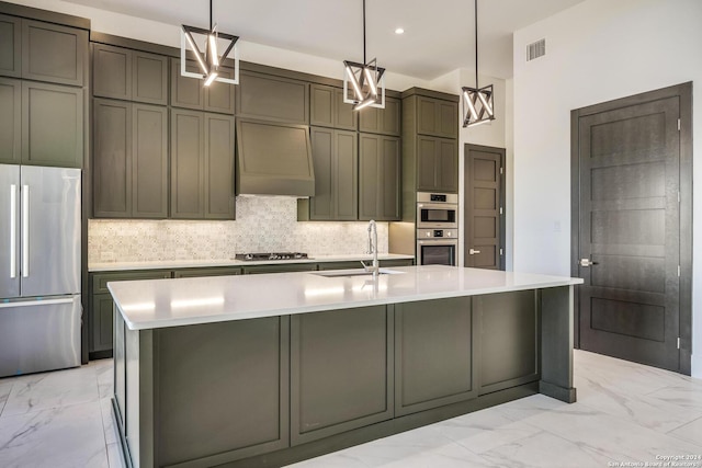 kitchen featuring custom range hood, stainless steel appliances, a kitchen island with sink, sink, and pendant lighting