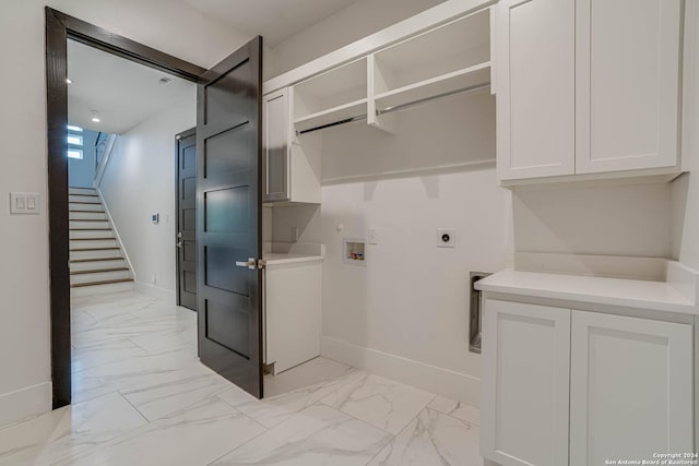 washroom featuring marble finish floor, washer hookup, cabinet space, and electric dryer hookup