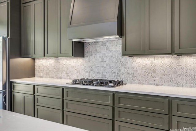 kitchen with stainless steel gas cooktop, backsplash, and custom exhaust hood