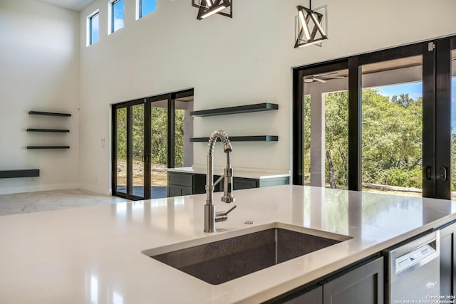 kitchen featuring a high ceiling, sink, and dishwasher