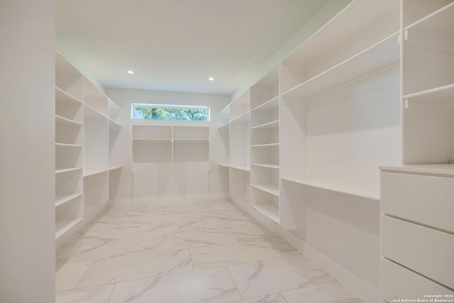 walk in closet with light tile floors