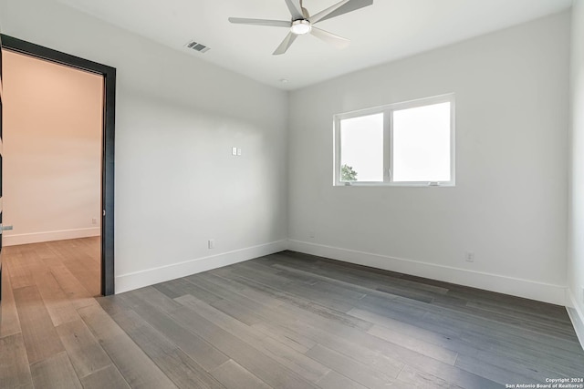 spare room featuring a ceiling fan, baseboards, visible vents, and wood finished floors