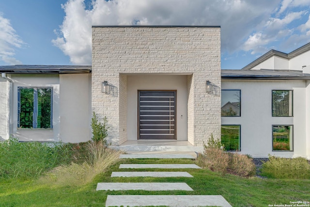 view of exterior entry featuring stucco siding