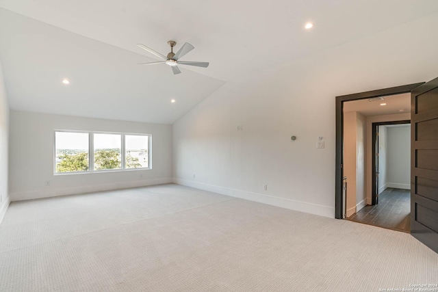 empty room featuring lofted ceiling, carpet floors, baseboards, and recessed lighting