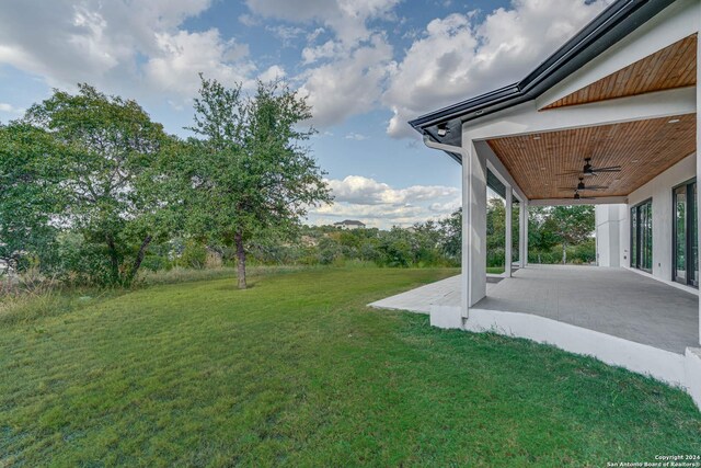 view of yard with a patio area and ceiling fan