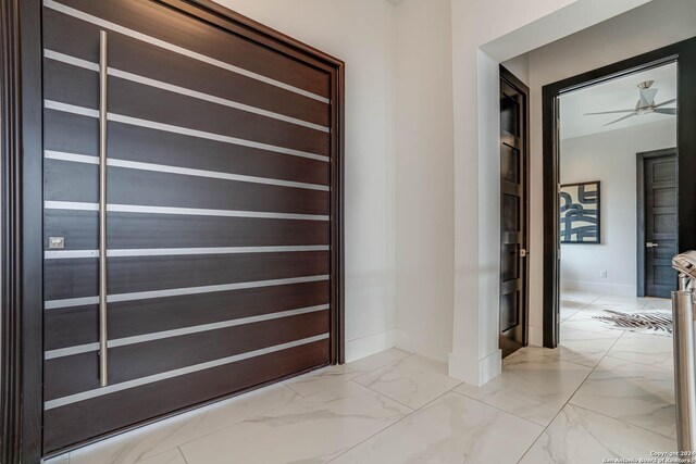 hallway with marble finish floor and baseboards