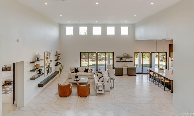 living area featuring marble finish floor, french doors, recessed lighting, and a healthy amount of sunlight