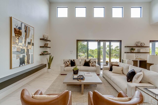 unfurnished living room featuring a towering ceiling and light tile flooring