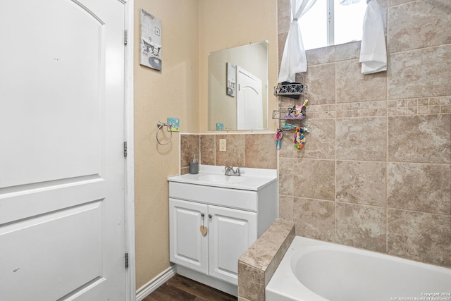 bathroom featuring vanity, hardwood / wood-style floors, and a tub