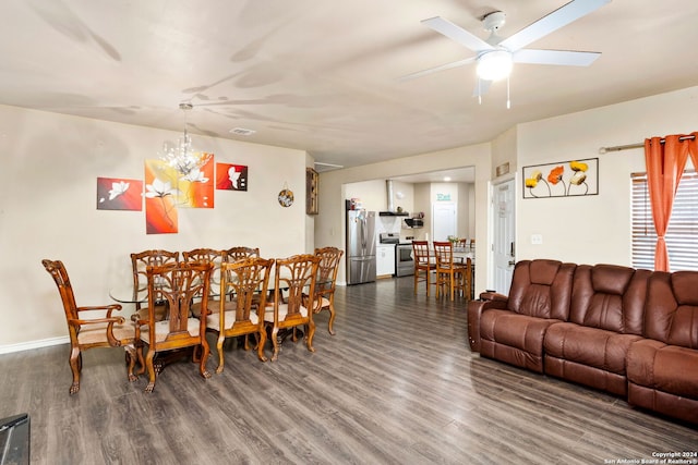 dining area with hardwood / wood-style flooring and ceiling fan with notable chandelier