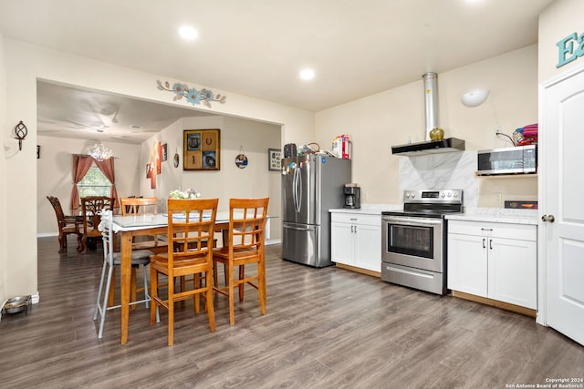 kitchen featuring white cabinetry, stainless steel appliances, dark hardwood / wood-style flooring, and decorative backsplash