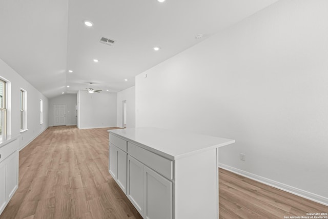 corridor with light hardwood / wood-style floors and lofted ceiling