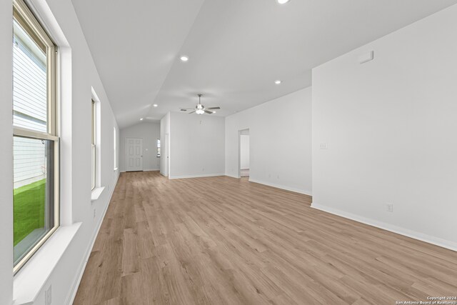 unfurnished living room featuring ceiling fan, lofted ceiling, and light wood-type flooring