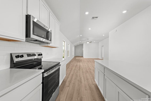 kitchen featuring ceiling fan, white cabinets, light wood-type flooring, and appliances with stainless steel finishes