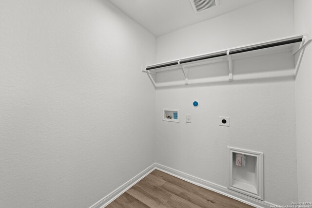 washroom featuring hookup for a gas dryer, hookup for a washing machine, wood-type flooring, and hookup for an electric dryer