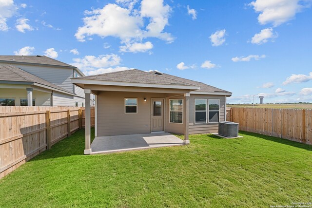 rear view of house featuring a yard, a patio, and central AC unit