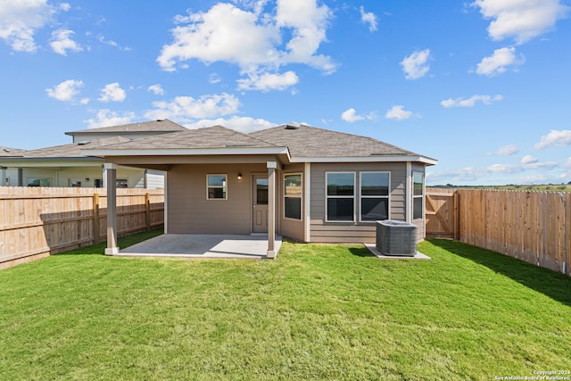 back of property with a patio area, a yard, and central AC