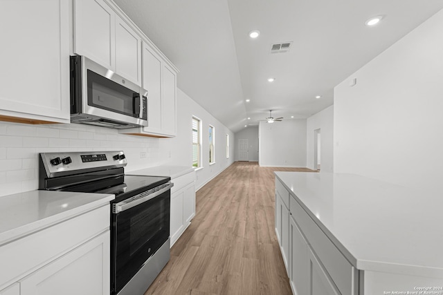 kitchen featuring white cabinets, ceiling fan, stainless steel appliances, and vaulted ceiling