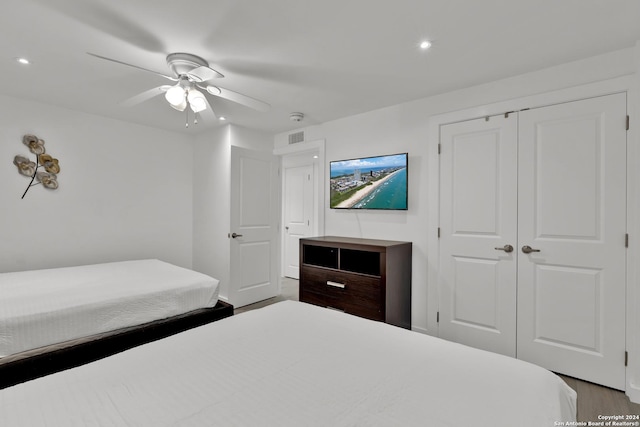 bedroom featuring hardwood / wood-style flooring, ceiling fan, and a closet