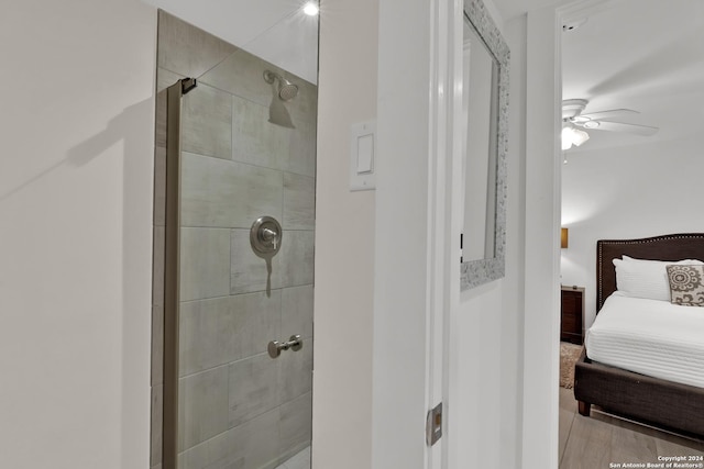 bathroom featuring ceiling fan, wood-type flooring, and a shower with door