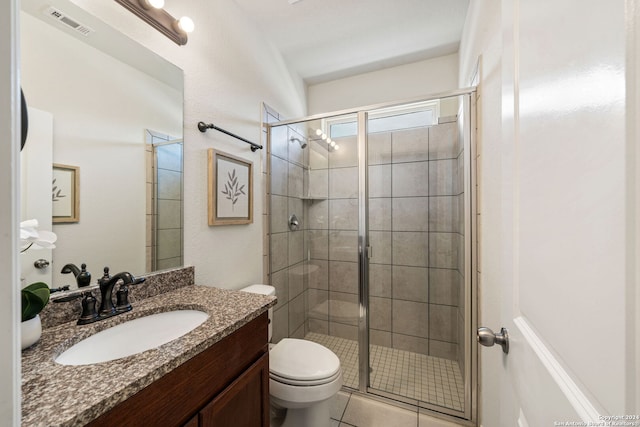 bathroom with tile patterned flooring, vanity, toilet, and walk in shower