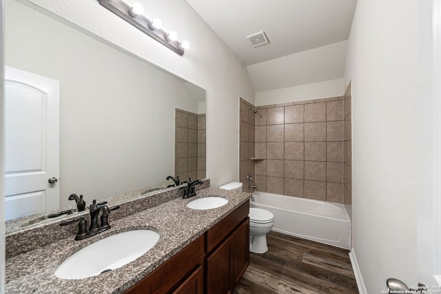 full bathroom featuring tiled shower / bath combo, toilet, wood-type flooring, and vanity