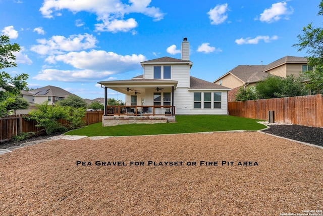 back of house featuring ceiling fan and a yard