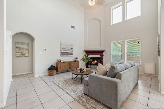 tiled living room with a high ceiling and ceiling fan