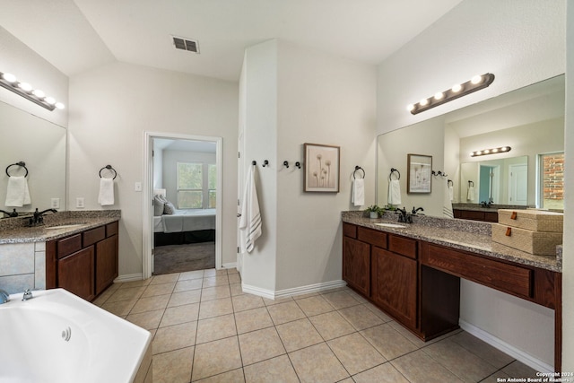 bathroom with tile patterned floors, vanity, and lofted ceiling