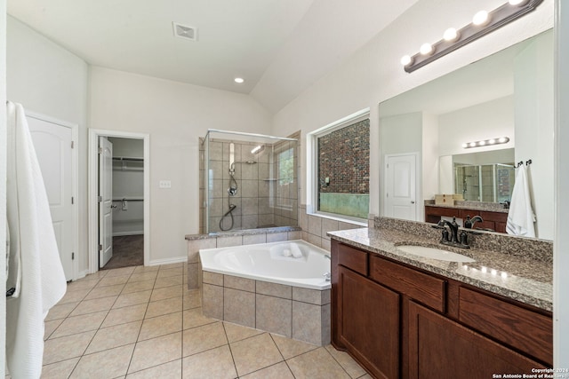 bathroom with tile patterned flooring, vanity, vaulted ceiling, and independent shower and bath