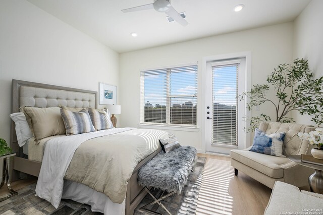 bedroom with hardwood / wood-style floors, access to outside, and ceiling fan